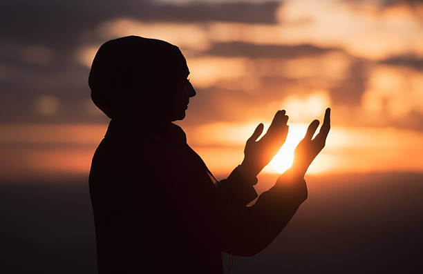 Silhouette of Muslim woman prayer having worship and praying with hands open doing dua to Allah at sunset. Silhouette of muslim woman prayer having worship and praying with hands open doing dua to Allah at sunset . High quality photo i love allah in arabic silhouettes stock pictures, royalty-free photos & images