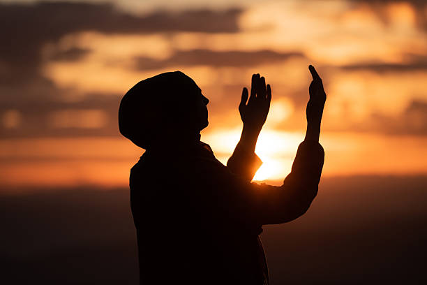 Muslim woman prayer praying with hands up open doing dua worship Allah. High quality photo