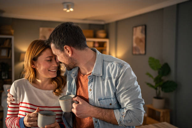 istock Loving couple sharing a tender moment at home with warm beverages 2205607270