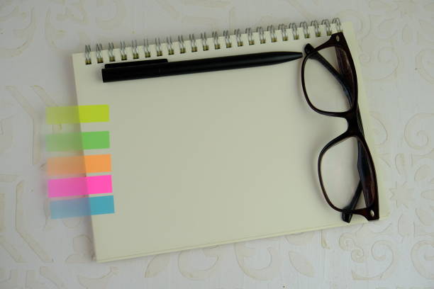 a blank note book on notice board for text space. Educational and financial concept with text space on brown background.