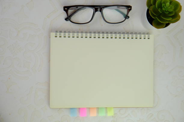 a blank note book on notice board for text space. Educational and financial concept with text space on brown background.