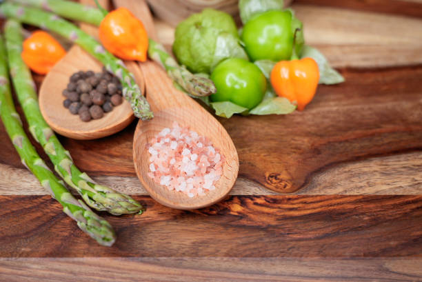 fresh vegetables and an old cleaver on top of an antique wooden chopping board near salt and pepper on a rustic tabletop, with copy space for your message