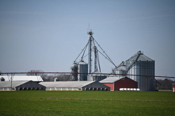 A potash plant with multiple dome-shaped storage buildings and conveyors viewed across farmland under cloudy skies in Saskatchewan, Canada.