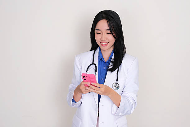 istock A young female doctor smiling when looking at her mobile phone 2205614565