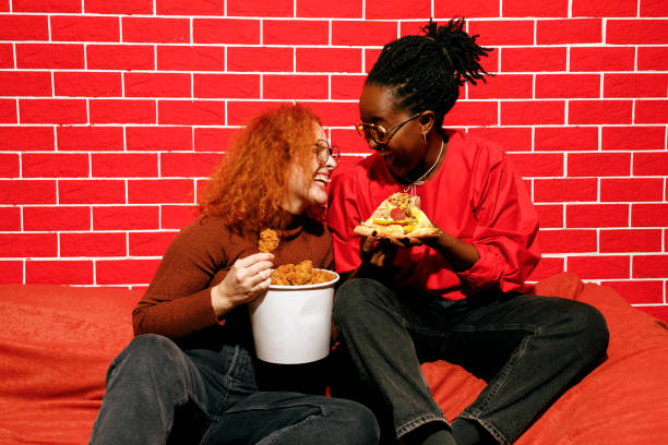 istock Two Friends Laughing and Enjoying Fast Food 2205615866