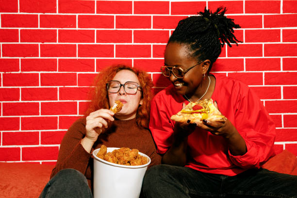 istock Two Friends Laughing and Enjoying Fast Food 2205615897