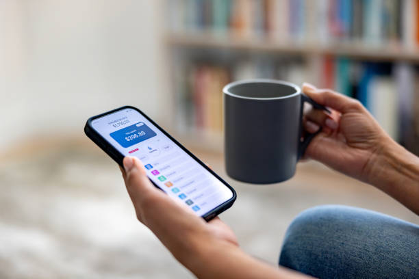 istock Close-up on a woman using an electronic banking app while drinking coffee 2205618162