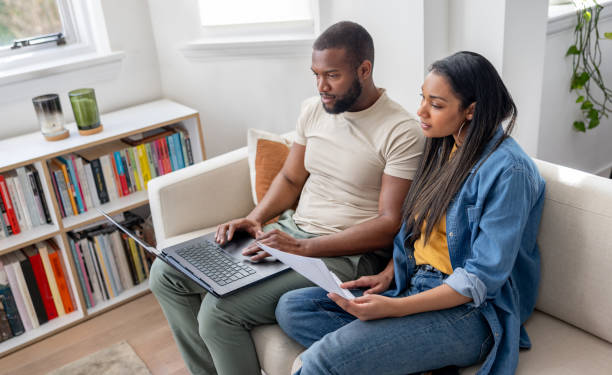 istock Couple using their laptop at home while paying bills online 2205619870