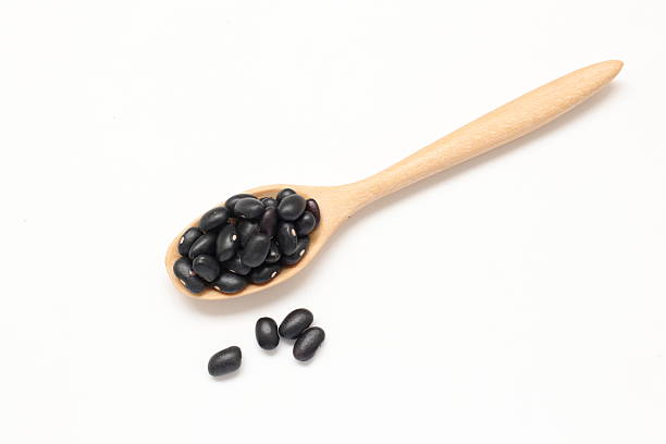 istock Black beans in spoon on white background 2205627159