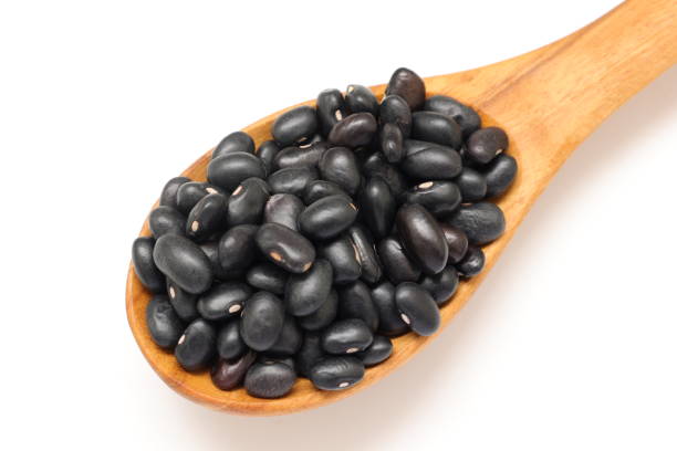 istock Black beans in spoon on white background 2205627181