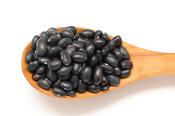 istock Black beans in spoon on white background 2205627189