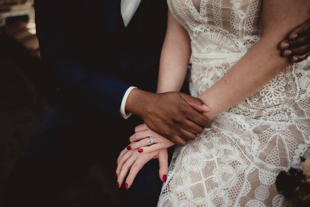 istock Bride and groom sitting together with amethyst wedding ring 2205629765