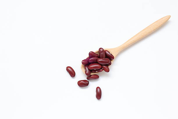 istock Red kidney beans in spoon on white background 2205629855