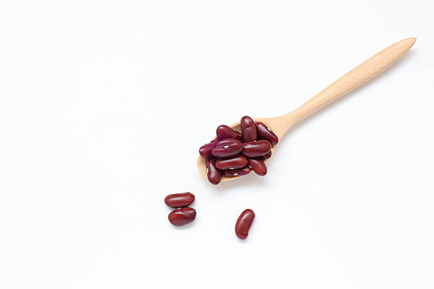 istock Red kidney beans in spoon on white background 2205629856