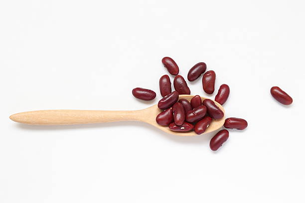 istock Red kidney beans in spoon on white background 2205629875