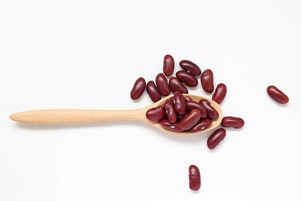istock Red kidney beans in spoon on white background 2205629878