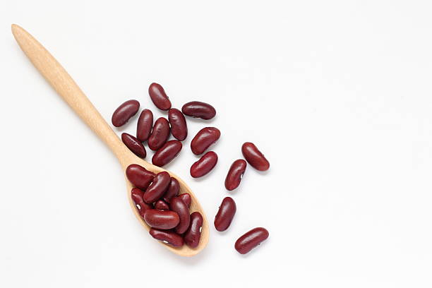 istock Red kidney beans in spoon on white background 2205629879