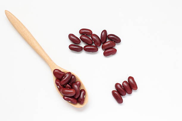 istock Red kidney beans in spoon on white background 2205629880