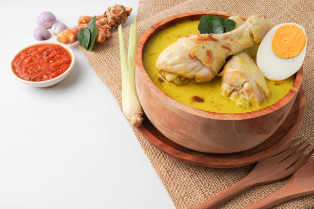 istock Lontong opor ayam is an Indonesian traditional dish usually served during eid Mubarak, Eid al Fitr holiday celebration with Ketupat Lebaran or rice cake dumpling and sambal chili sauce. 2205637159