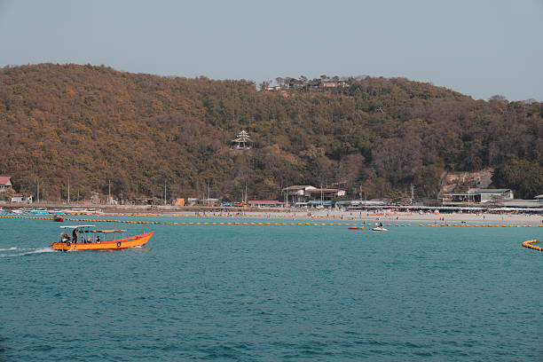 A serene coastal scene with colorful boats on blue water, alongside a sandy beach perfect for relaxation