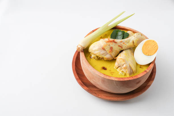 istock Lontong opor ayam is an Indonesian traditional dish usually served during eid Mubarak, Eid al Fitr holiday celebration with Ketupat Lebaran or rice cake dumpling and sambal chili sauce. 2205639149