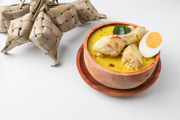 istock Lontong opor ayam is an Indonesian traditional dish usually served during eid Mubarak, Eid al Fitr holiday celebration with Ketupat Lebaran or rice cake dumpling and sambal chili sauce. 2205639199