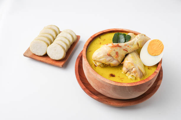 istock Lontong opor ayam is an Indonesian traditional dish usually served during eid Mubarak, Eid al Fitr holiday celebration with Ketupat Lebaran or rice cake dumpling and sambal chili sauce. 2205639203