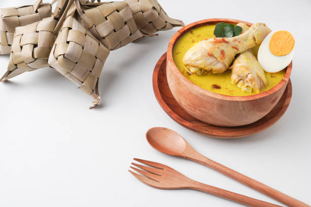 istock Lontong opor ayam is an Indonesian traditional dish usually served during eid Mubarak, Eid al Fitr holiday celebration with Ketupat Lebaran or rice cake dumpling and sambal chili sauce. 2205639268