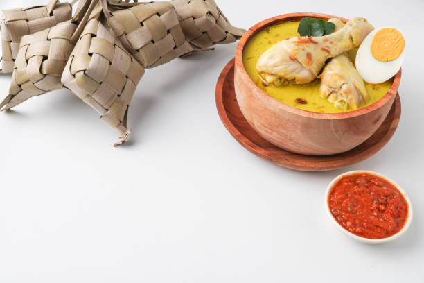 istock Lontong opor ayam is an Indonesian traditional dish usually served during eid Mubarak, Eid al Fitr holiday celebration with Ketupat Lebaran or rice cake dumpling and sambal chili sauce. 2205639280