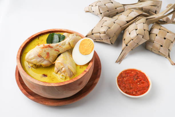 istock Lontong opor ayam is an Indonesian traditional dish usually served during eid Mubarak, Eid al Fitr holiday celebration with Ketupat Lebaran or rice cake dumpling and sambal chili sauce. 2205639345
