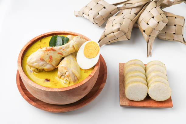 istock Lontong opor ayam is an Indonesian traditional dish usually served during eid Mubarak, Eid al Fitr holiday celebration with Ketupat Lebaran or rice cake dumpling and sambal chili sauce. 2205639346