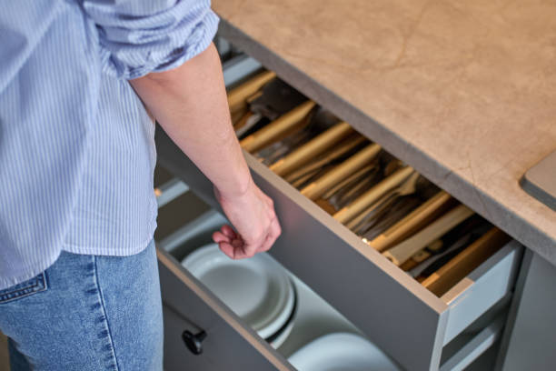 istock Person opening kitchen drawer with cutlery in cabinet 2205640799