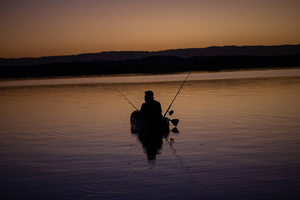 istock fisherman in a kayak during sunrise 2205646601