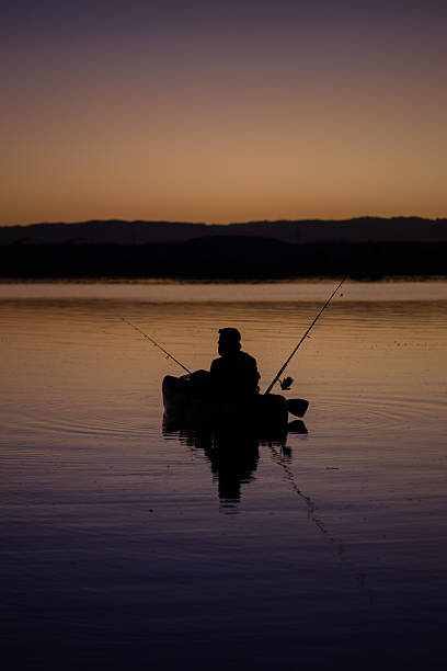 istock fisherman in a kayak during sunrise 2205646603