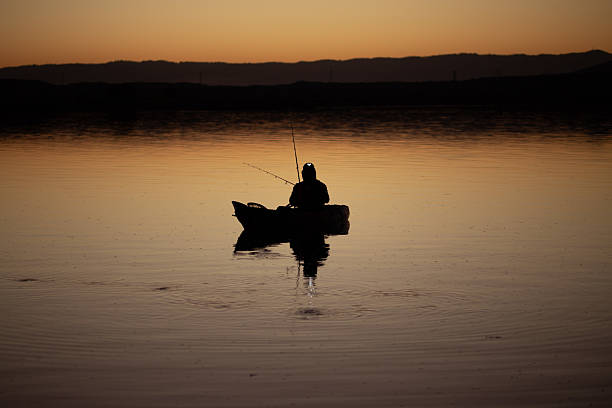 istock fisherman in a kayak during sunrise 2205646622