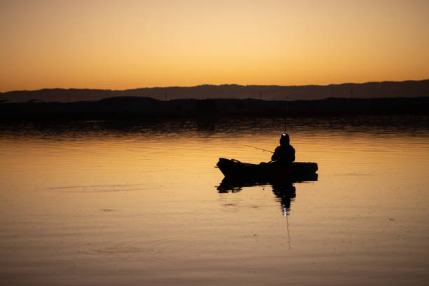 istock fisherman in a kayak during sunrise 2205646624