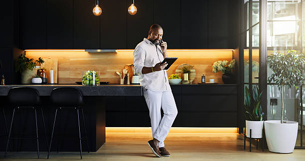 istock Black man, talking and phone call on tablet at house for research, schedule update and feedback. Person, mobile or communication with information, online negotiation and investment deal for proposal 2205648970