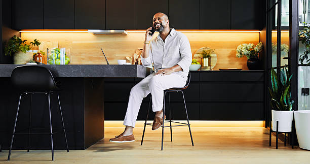 istock Happy, black man and remote work with phone call at house for communication, schedule update and feedback. Freelancer, mobile and discussion with online negotiation, investment deal and proposal idea 2205648995