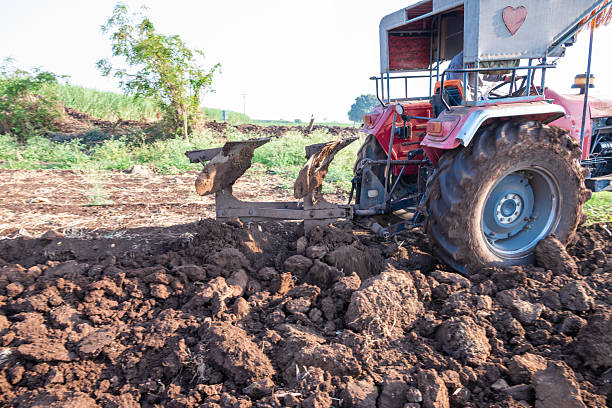 Tractor plows agricultural field. Processing the field with a tractor. The tractor is processing the field. Agriculture industry, cultivation of land. Concept production food