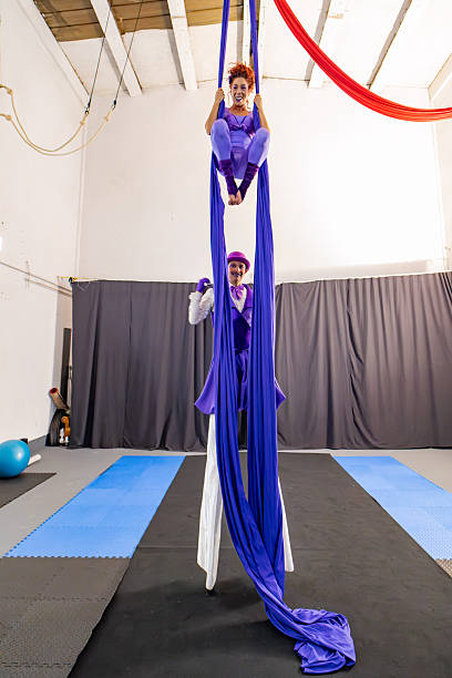 istock Two acrobats performing aerial silk discipline in gym 2205653477