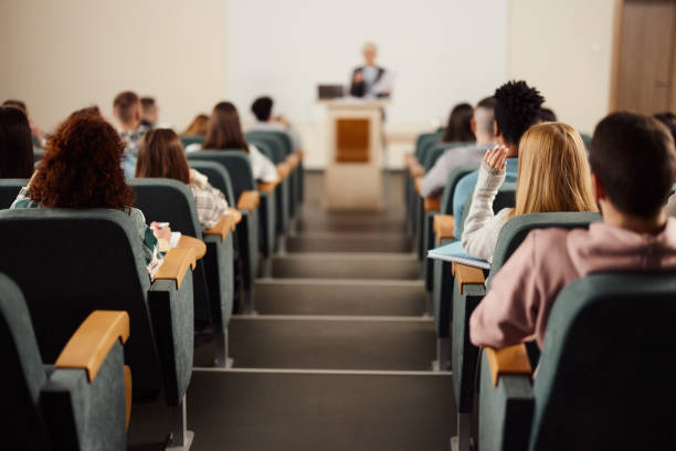 istock Rear view of large group of students on a class at lecture hall. 2205654980