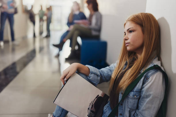 istock Female student relaxing on floor during a break in a hallway. 2205655229