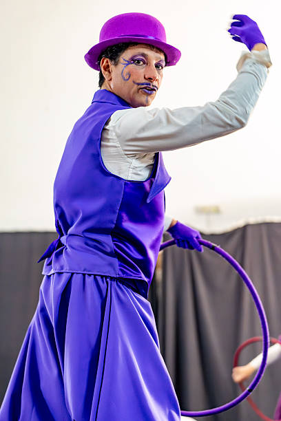 istock Clown performing with hula hoop in purple costume 2205658091