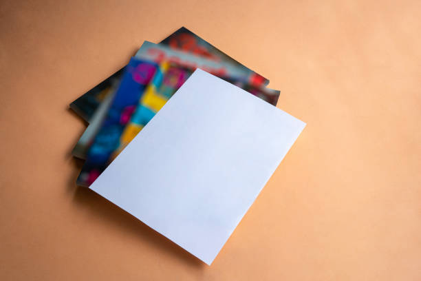 Stack of magazines with white paper cover on top. Copy space.