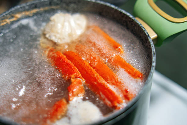 istock crab claws submerged in boiling water inside a green pot, showcasing the cooking process of fresh seafood. Ideal for culinary, food preparation, and seafood-themed content 2205658916