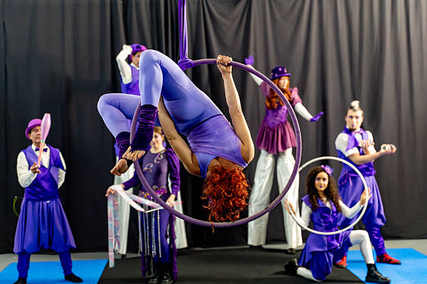 istock Acrobat hanging upside down on an aerial hoop during circus show 2205659345