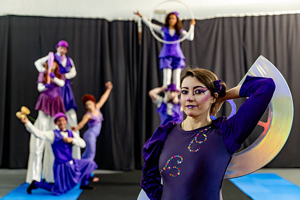 Circus performers posing with purple costumes and props