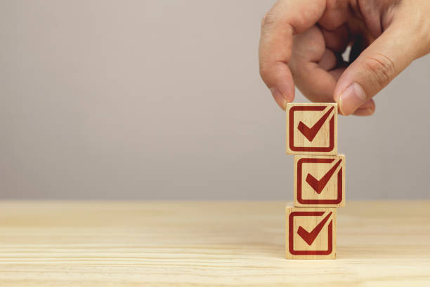 istock Hand picks up a stack of wooden blocks with check icons. checklist survey concept 2205660685