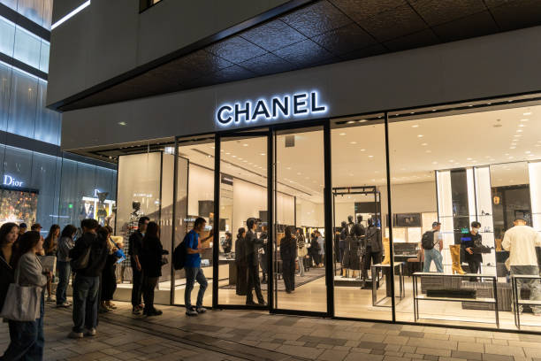 Tokyo, Japan - October 26, 2024 : Shoppers queuing outside the Chanel Boutique in Tokyo, Japan.