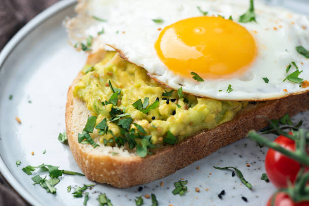 istock Avocado toast with fried egg and chopped greens 2205662863